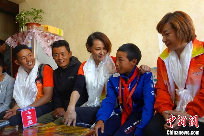 圖為世界冠軍在拉薩進(jìn)行家訪，與青少年運(yùn)動員聊天?！∪轿木?攝