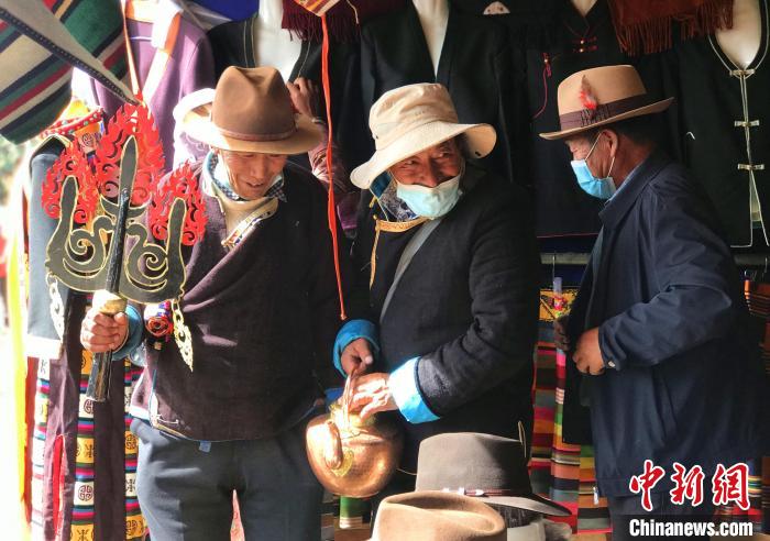 圖為三位藏族老人在集市上聊天交談?！∪轿木?攝