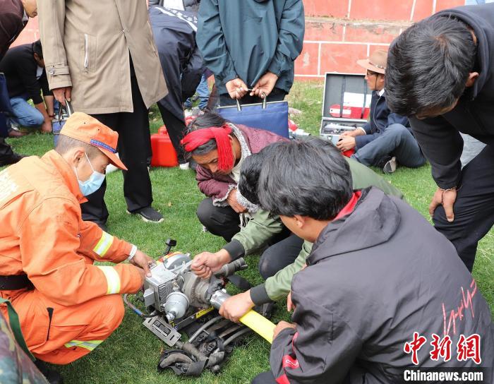 圖為森林消防員為護林員講解滅火裝備的使用方法?！〔际猩窒乐ш?供圖