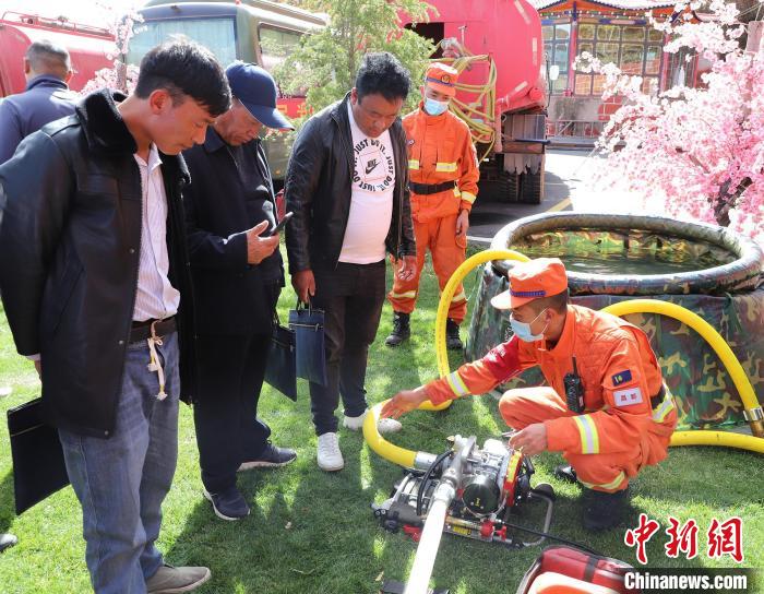 圖為森林消防員為護林員講解滅火裝備的使用方法。　昌都市森林消防支隊 供圖