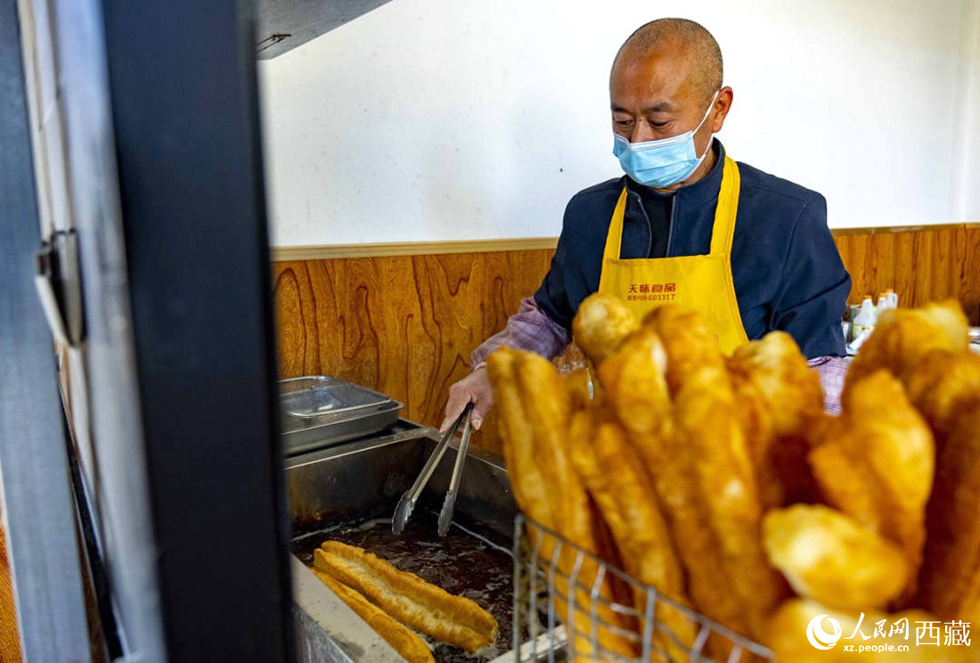 早餐店老板正在炸油條。人民網(wǎng) 次仁羅布攝
