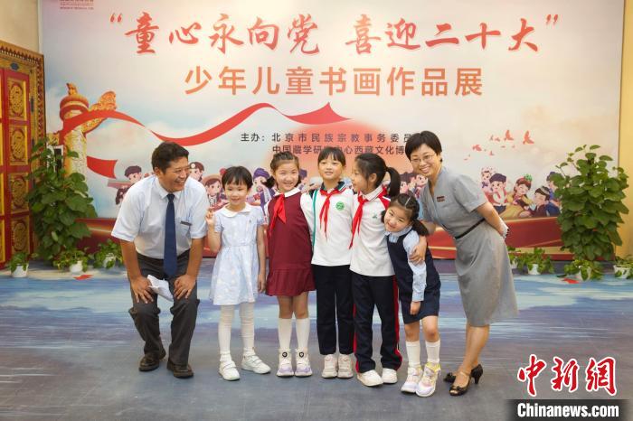 圖為與會(huì)嘉賓與入選畫(huà)作的“小作者”們?cè)谡褂[上合影?！≈袊?guó)藏學(xué)研究中心供圖
