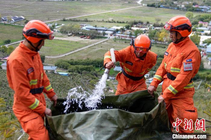 技能大練兵過程中，消防員在陡坡上向蓄水池注水?！±顕鵂c 攝