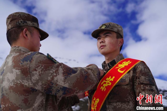 排長王朝偉(圖左)給退伍老兵佩戴大紅花。　西藏山南軍分區(qū)某團(tuán)供圖