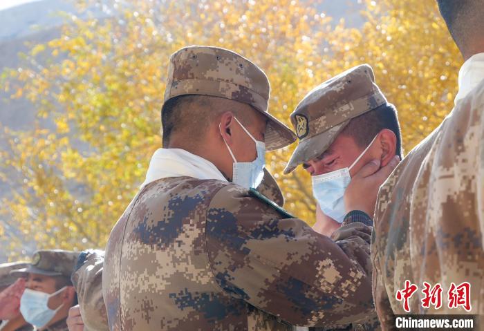 圖為什布奇邊防連退伍老兵與戰(zhàn)友相擁而泣，依依惜別?！⌒觳?攝