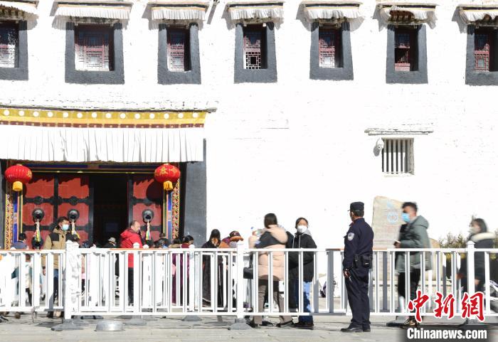 圖為1月23日，布達(dá)拉宮廣場(chǎng)派出所民警正在引導(dǎo)游客?！∝暩聛硭?攝