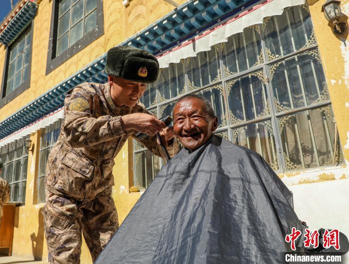 圖為阿里軍分區(qū)某邊防團(tuán)官兵為駐地群眾理發(fā)迎藏歷新年?！〉┰鰝愔?攝