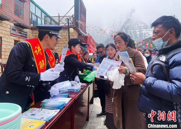 圖為山南玉麥邊境派出所民警為轄區(qū)群眾發(fā)放法律知識(shí)宣傳單?！＄婗?　攝