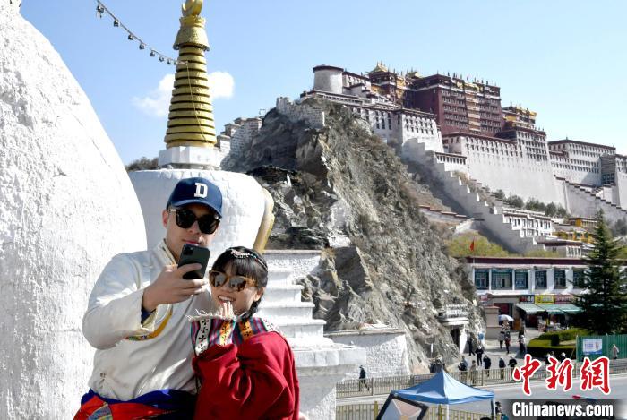 4月17日，游客身著藏式元素服裝在拉薩布達(dá)拉宮觀景臺(tái)拍照留念?！±盍?攝