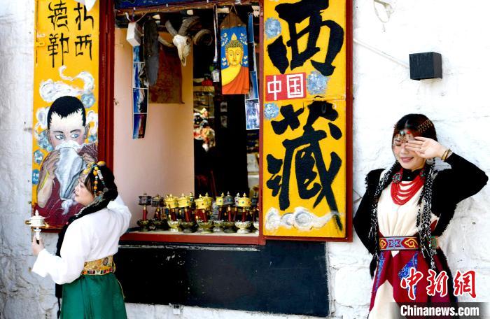 4月17日，游客身著藏式元素服裝在拉薩八廓街拍照留念。　李林 攝