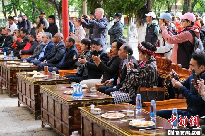 5月19日，中外嘉賓在羅布林卡和游客一起觀看藏戲。　江飛波 攝