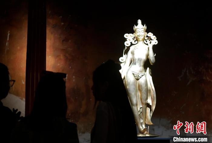 圖為觀眾正在欣賞展覽中的雕塑作品《八萬四千年》?！±盍?攝