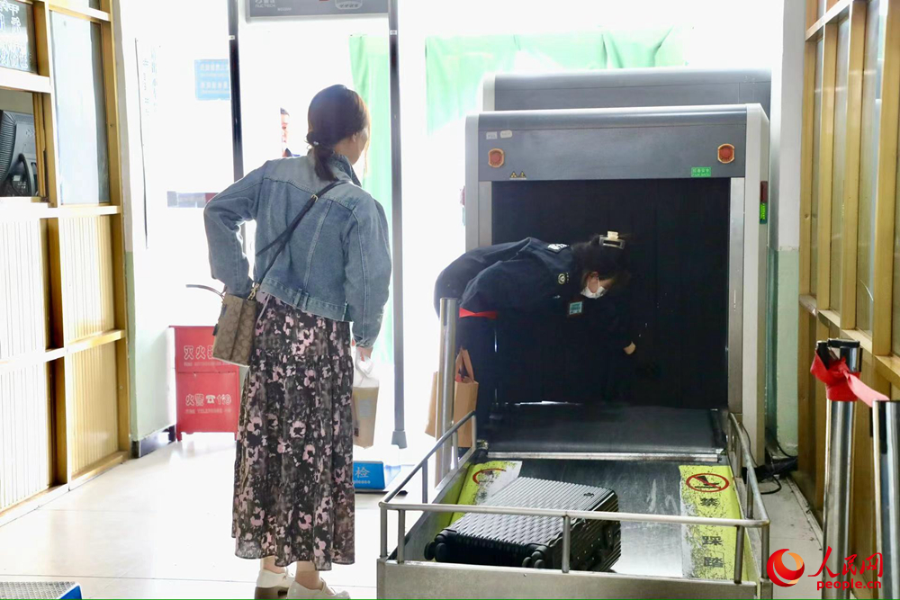車站工作人員幫旅客提取行李。人民網(wǎng)記者 次仁羅布攝
